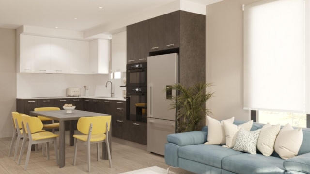 A rendering of The Zivar kitchen/living area. An angled view of a kitchen table with yellow chairs and a rectangle wooden modern table with blue couch, white pillows and white square coffee table.