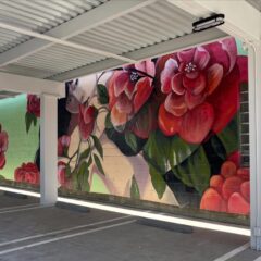 Vibrant floral mural on building wall.