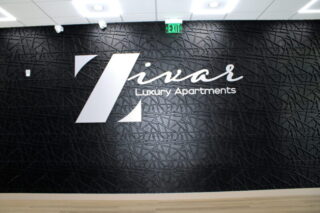 Zivar Luxury Apartments logo on textured wall.