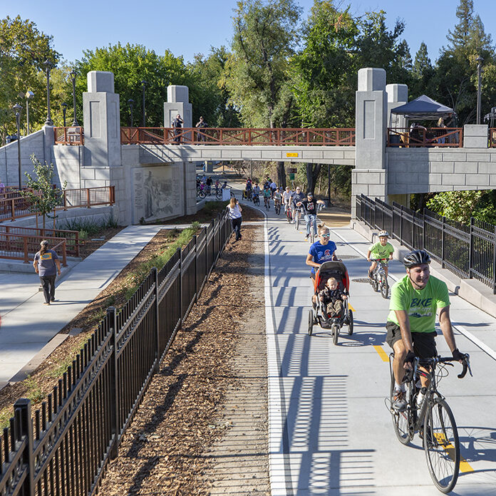 Man and kids walking and biking through downtown over Roseville Ca bridge