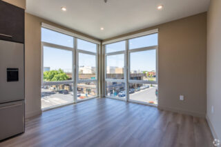Empty room with corner windows and street view.