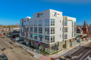 Modern luxury apartment building on busy city corner.