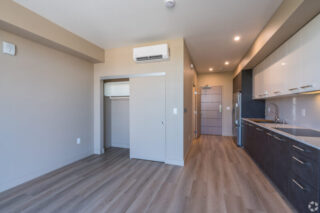 Modern studio apartment with kitchen and closet space.