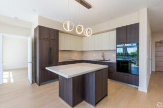 Modern kitchen with island and pendant lights.