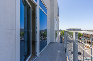 Modern apartment balcony overlooking urban street view.