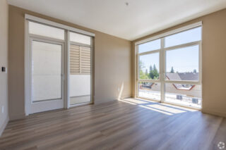 Sunlit empty room with large windows and door
