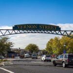 Vernon Street sign over road with cars.